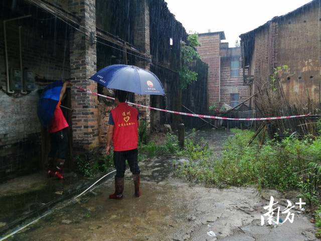 黨群志愿者冒雨拉起警戒線。